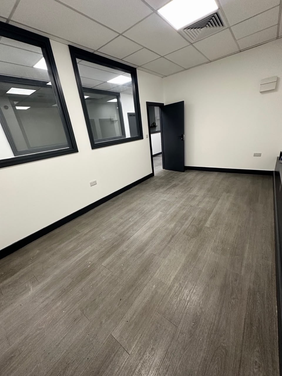 Wide view of an empty unit with black framed windows
